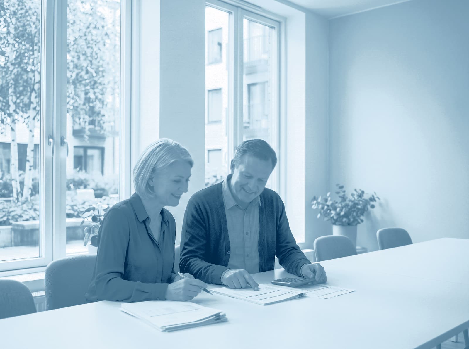 Twee bestuursleden nemen aan een witte tafel de begroting door, met een rekenmachine