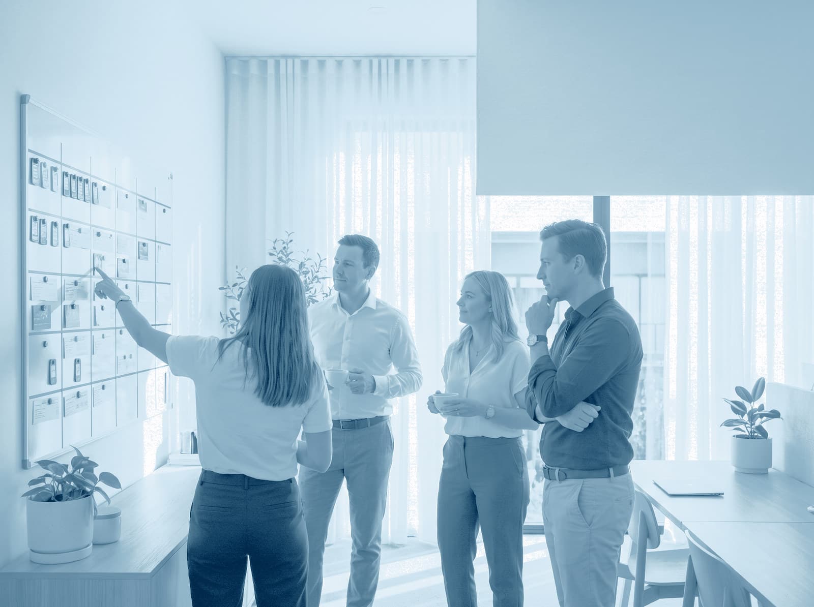 Een team van beheerders plant de week bij een groot planbord aan de muur
